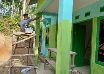 Anggota Koramil Gumeg Lakukan Perapian Pengecatan rumah Penerima Manfaat TMMD