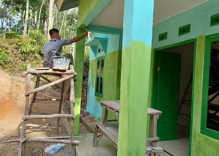 Anggota Koramil Gumeg Lakukan Perapian Pengecatan rumah Penerima Manfaat TMMD